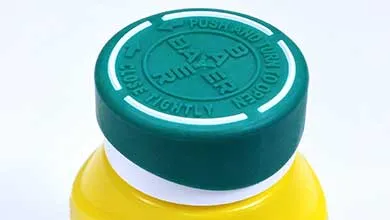 Yellow medicine bottle with a green, child-proof cap embossed with the Bayer logo and "PUSH AND TURN TO OPEN" instructions, on a white background.